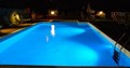 A pool at nighttime with lights on