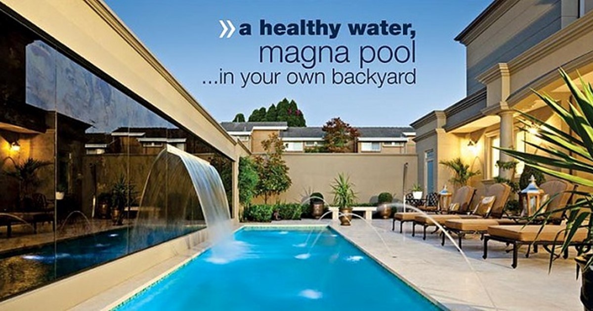 Long pool with water features in fancy home at dusk