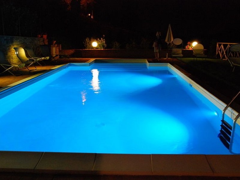 A pool at nighttime with lights on