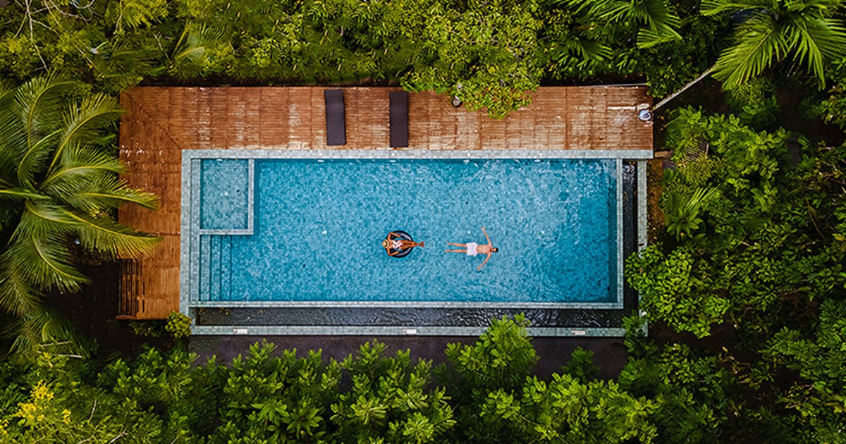 Pool surrounded by deck and lush trees