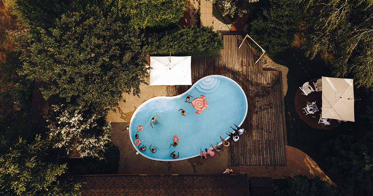 Pool with large deck and forest surrounding it