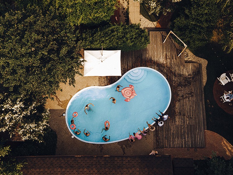 Pool with large deck and forest surrounding it